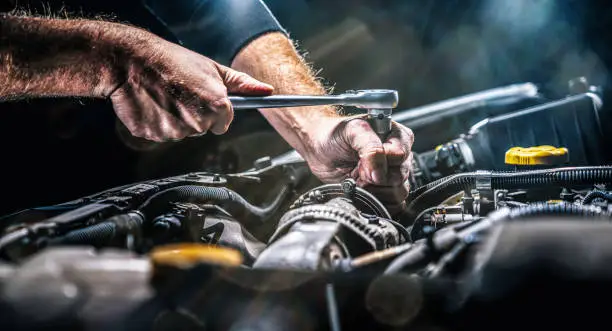 auto-mechanic-working-on-car-engine-in-mechanics-garage-repair-service-authentic-close-up-shot