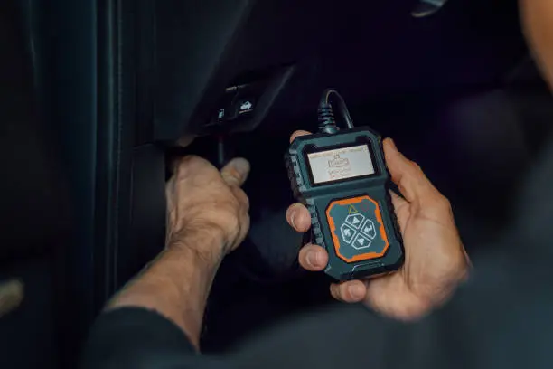 car-mechanic-using-obd2-scanner-code-reader-tool-to-check-engine-errors-and-for-diagnostics
